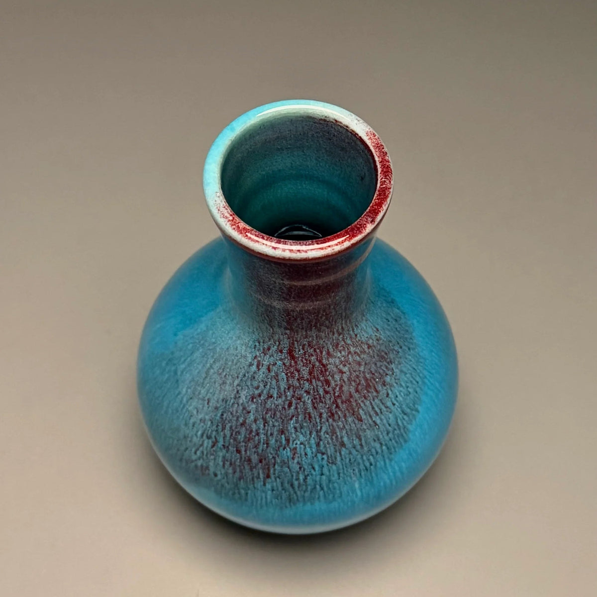 A small ceramic vase with a rounded bulbous body and a narrow neck made by Ben Owen III in Seagrove, North Carolina.
