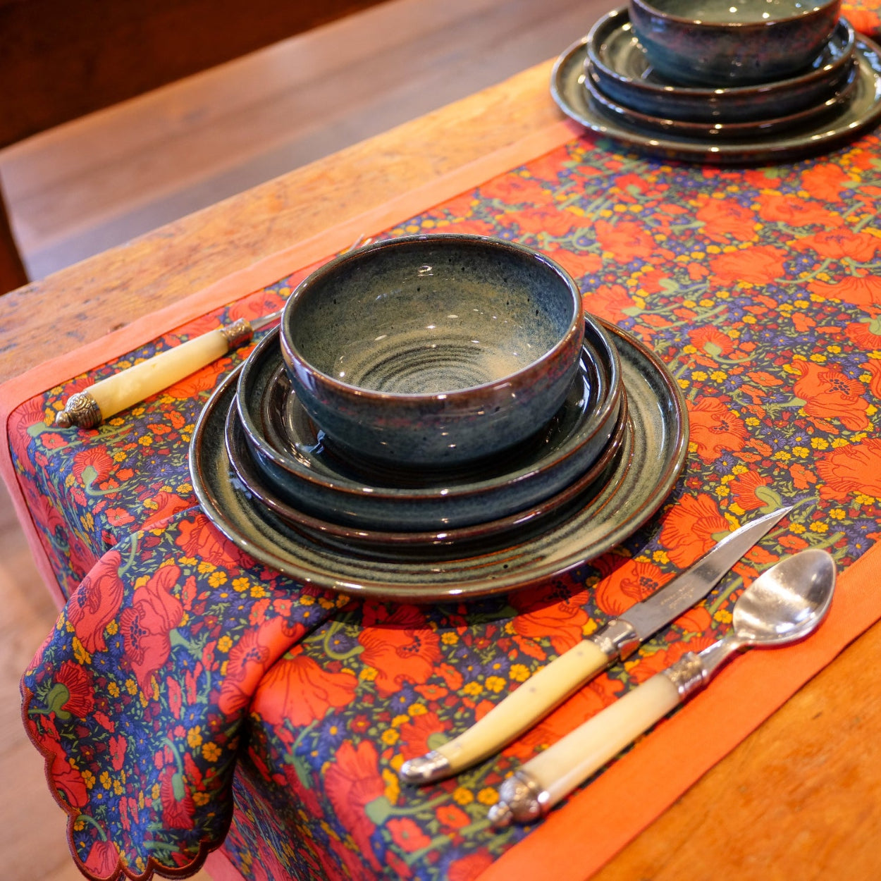 Place setting atop a Clementina patter table runner and napkin.