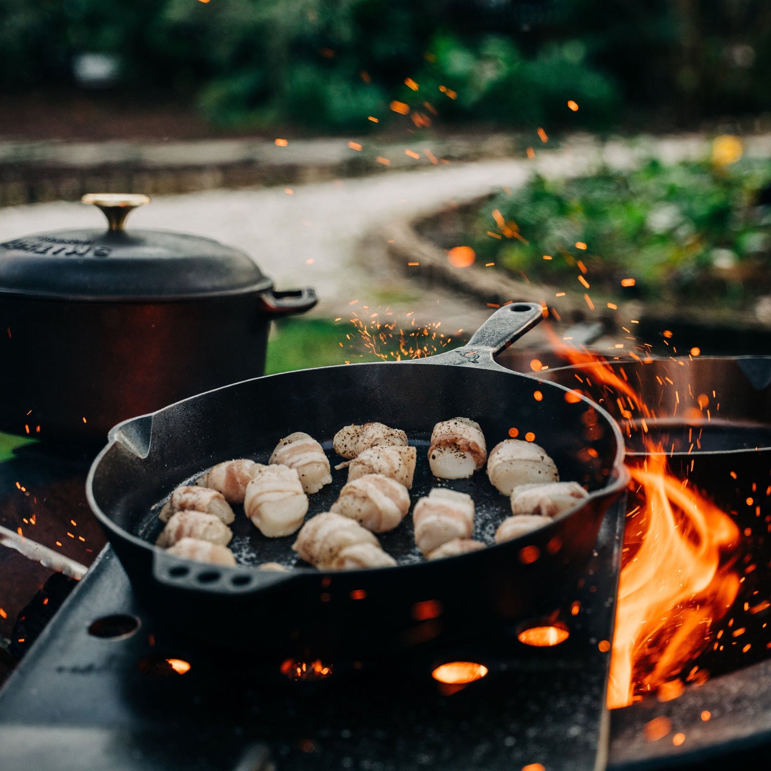 Cast iron pan with food over a campfire outdoors