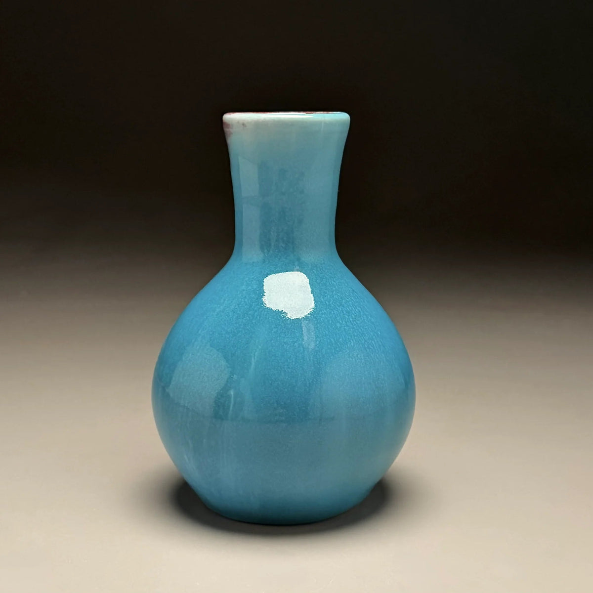 A small ceramic vase with a rounded bulbous body and a narrow neck made by Ben Owen III in Seagrove, North Carolina.