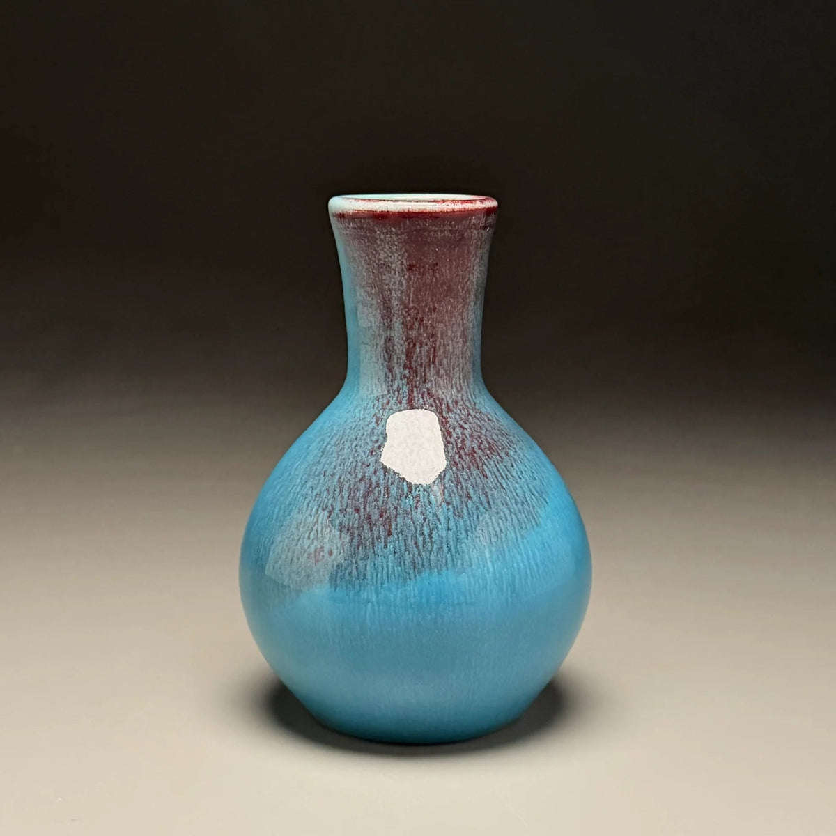 A small ceramic vase with a rounded bulbous body and a narrow neck made by Ben Owen III in Seagrove, North Carolina.