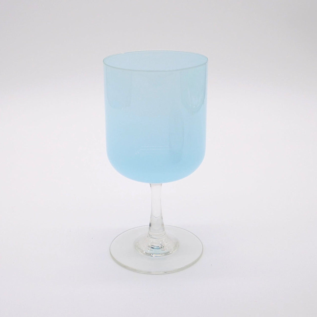 A hand-blown light blue colored stemware glass with a clear stem and base, displayed against a white background.