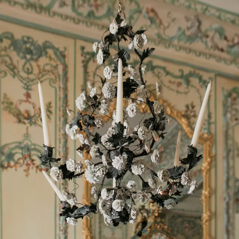 Decorative chandelier hanging in a room with ornate wallpaper