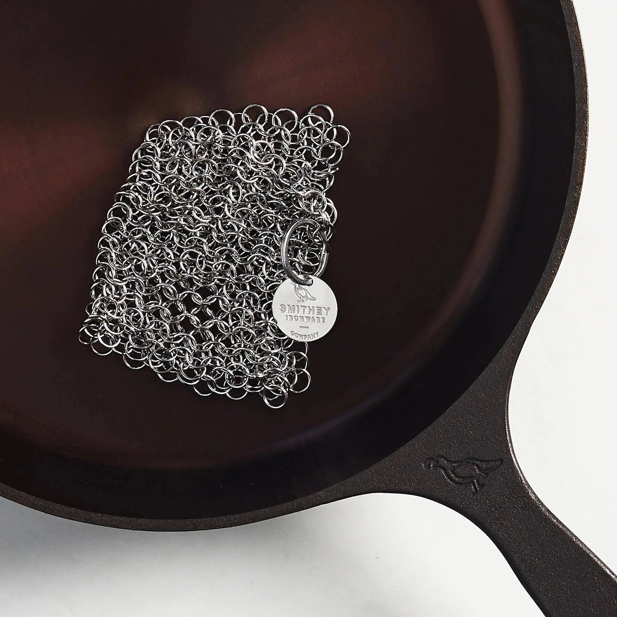 Smithey chainmail pan scrubber in a cast iron pan