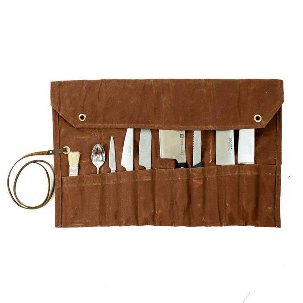 A closed waxed canvas chef knife roll with kitchen knives
